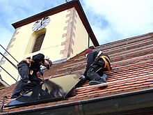 Handwerker montieren Solarpanele auf das Dach der Salvatorkirche in Ungstein. © Kretzschmar 
